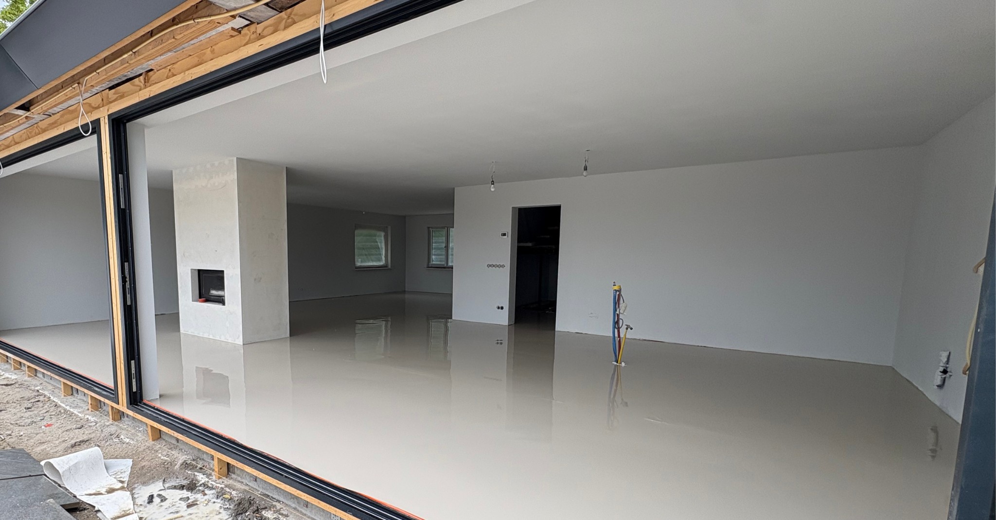 Een nieuwbouwwoning met een spiegelgladde, net gegoten egalinevloer