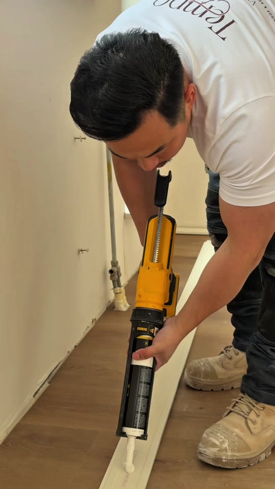 Kelvin kit een plint af langs een nieuwe PVC-vloer