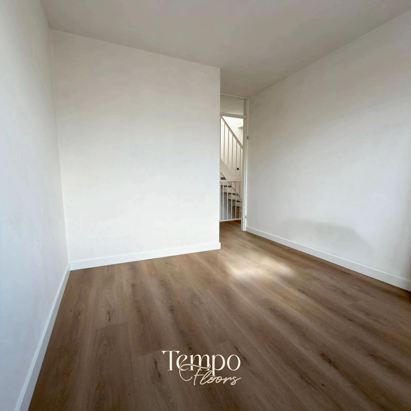 Slaapkamer met rechte PVC-stroken en witte plinten